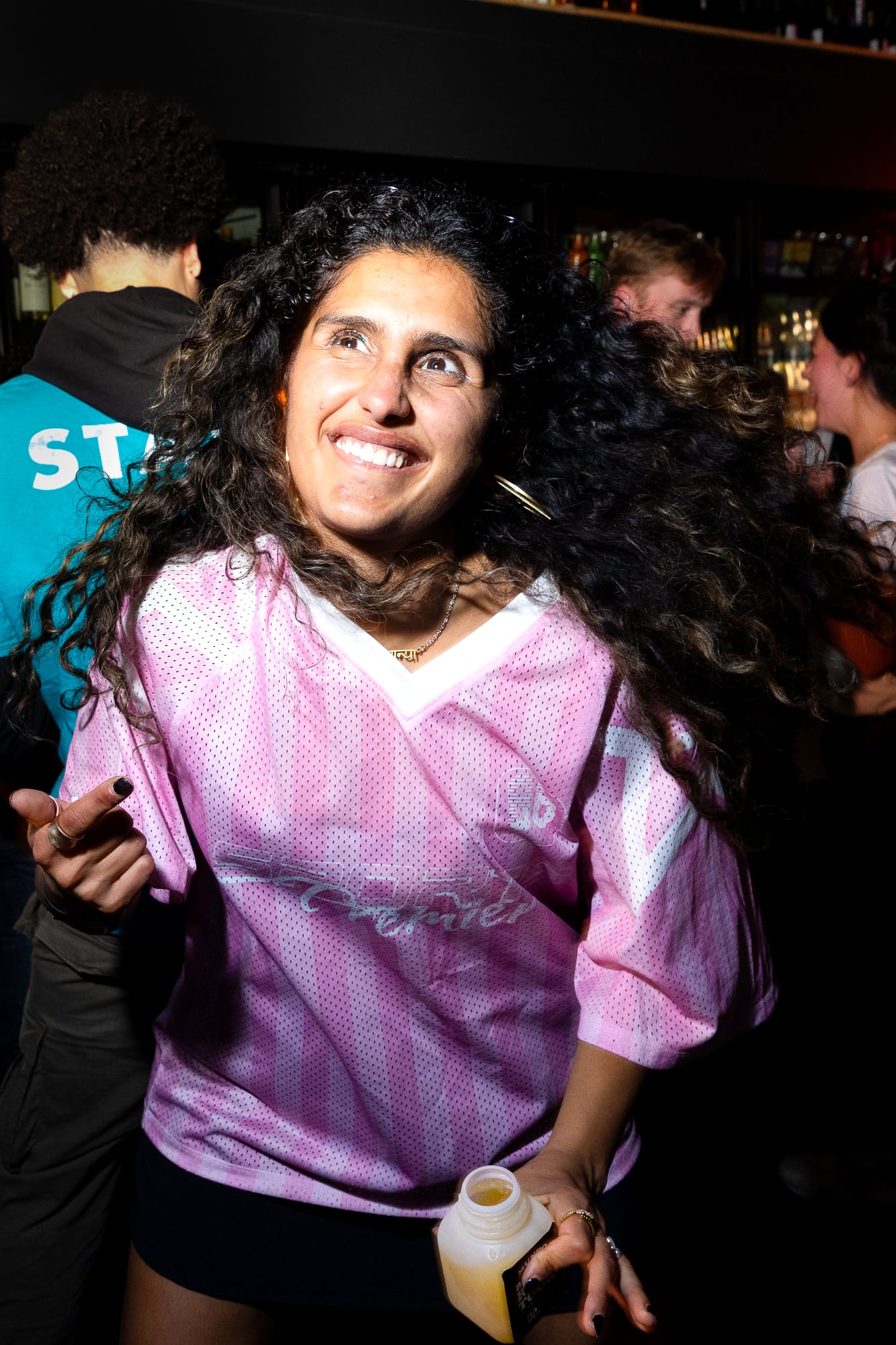 A person dances with a drink in their hand 