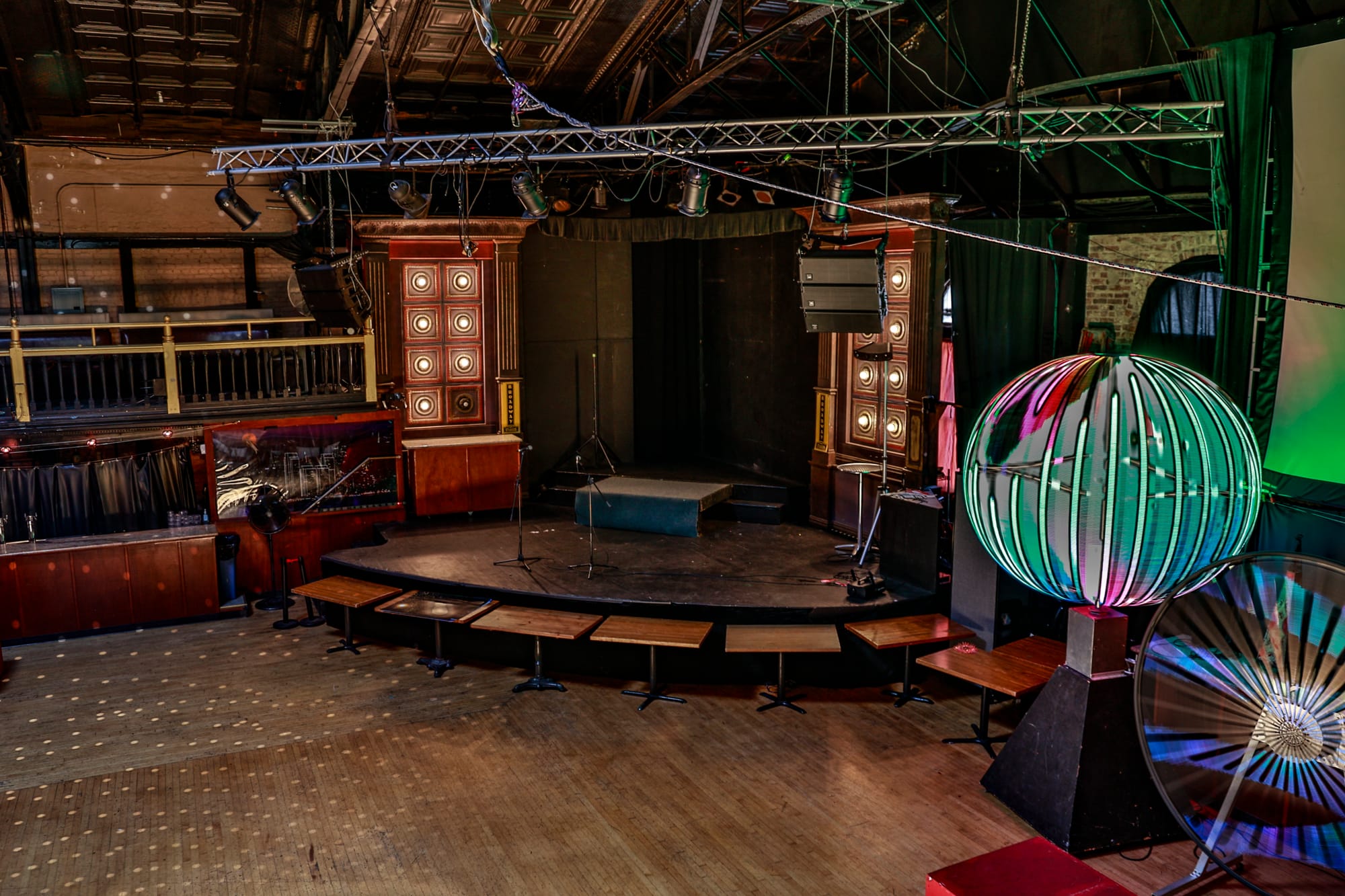 a stage with lights and a hardwood floor in an empty ballroom