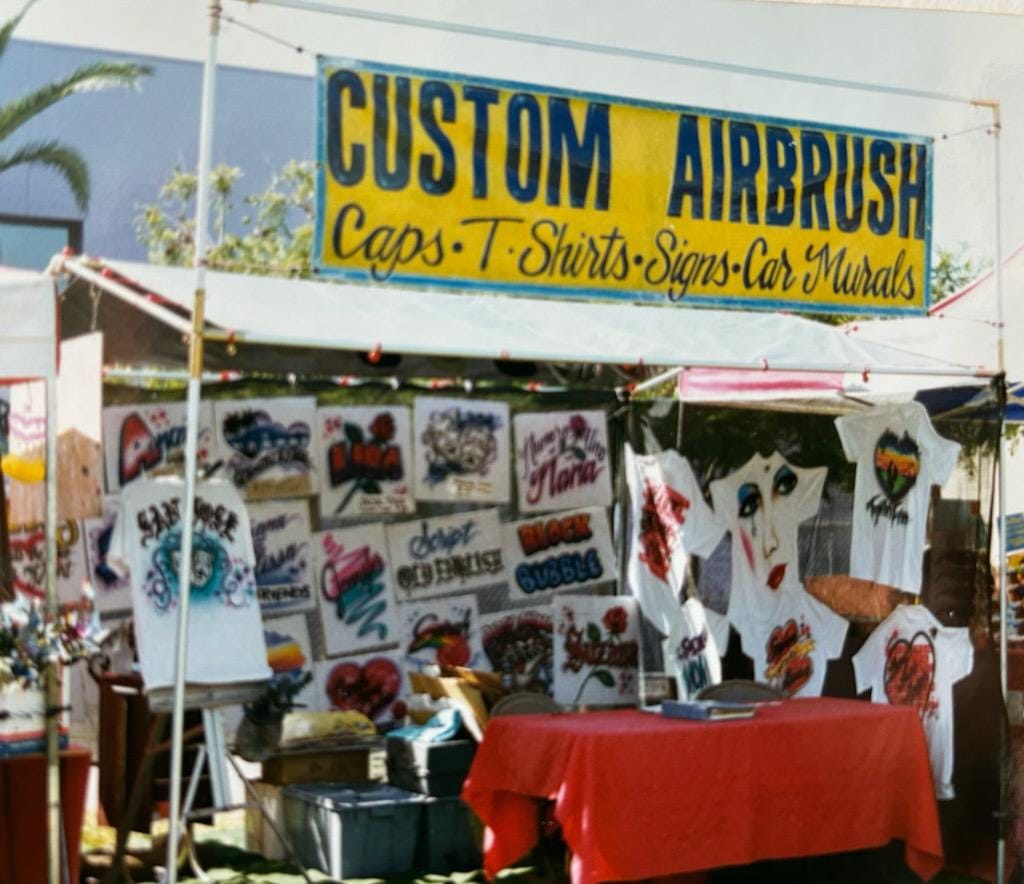 Scanned photograph of a stall for selling airbrushed work.