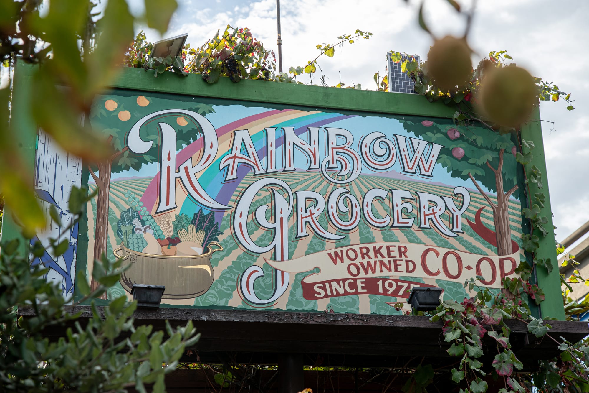 a painted sign that reads 'rainbow grocery, worker owned co-op since 1975'
