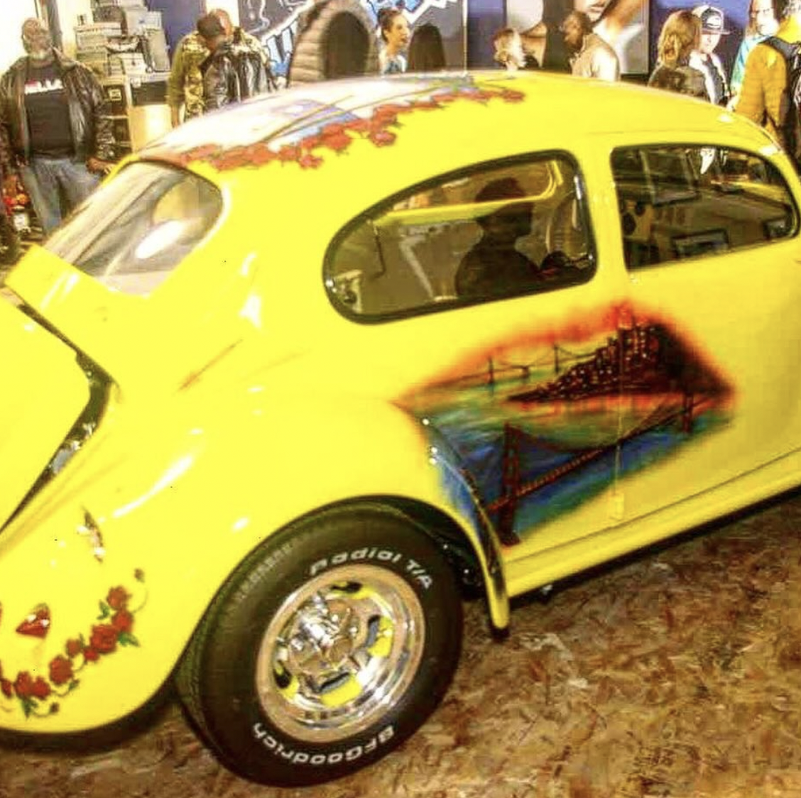 Yellow Volkswagon Beetle with the San Francisco skyline airbrushed on the back door.