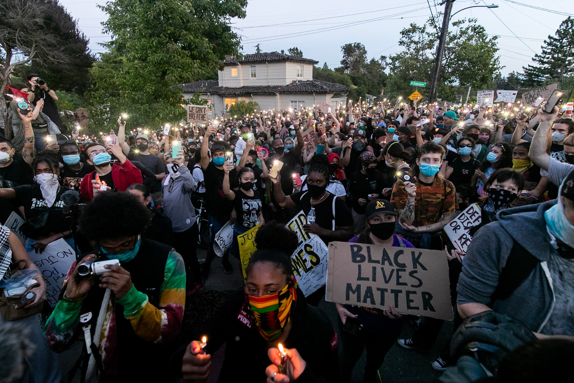 Hundreds of protesters hold their lighters and smart phone lights outside of Libby Schaaf's home. 