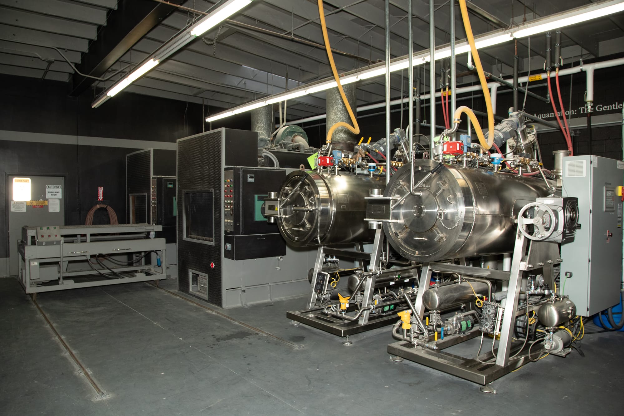 Two cylindrical machines stand in a warehouse.