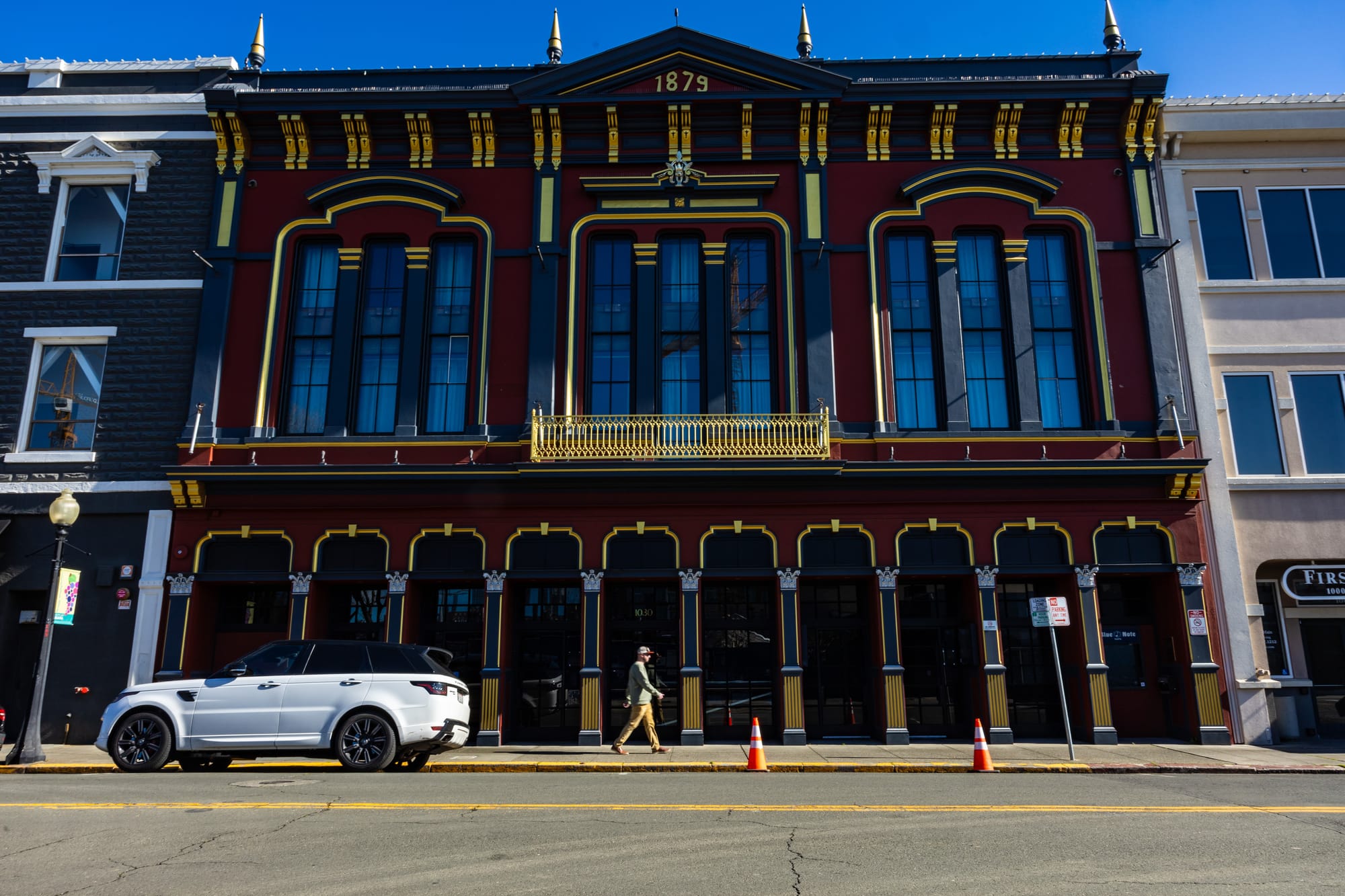A brown building with columns and yellow accents.