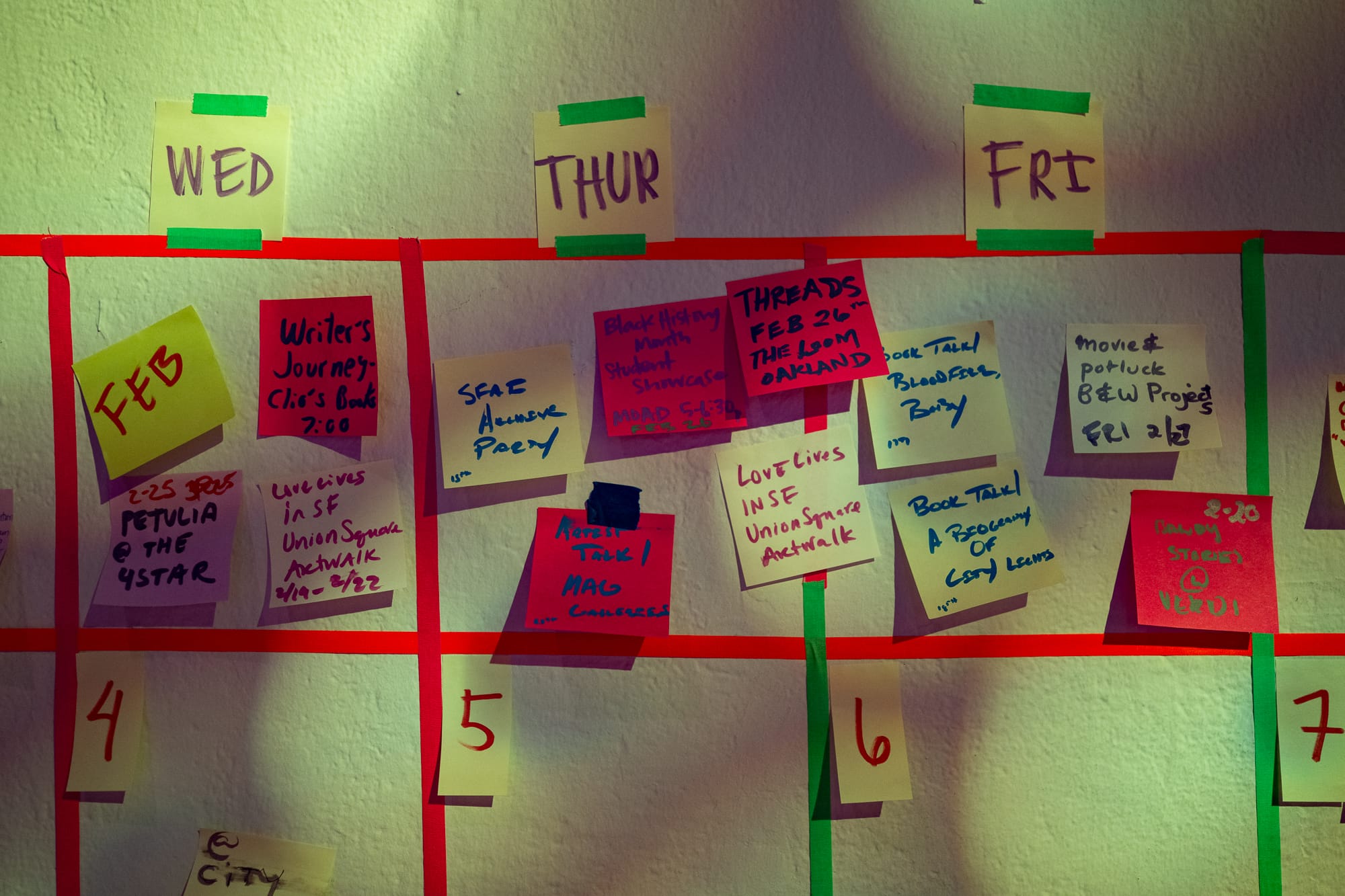 a wall with post-it notes featuring arts and culture events