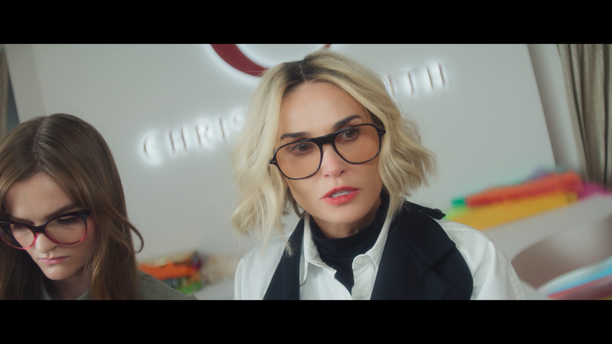 two women in glasses, the one on the right is Demi Moore with blonde hair