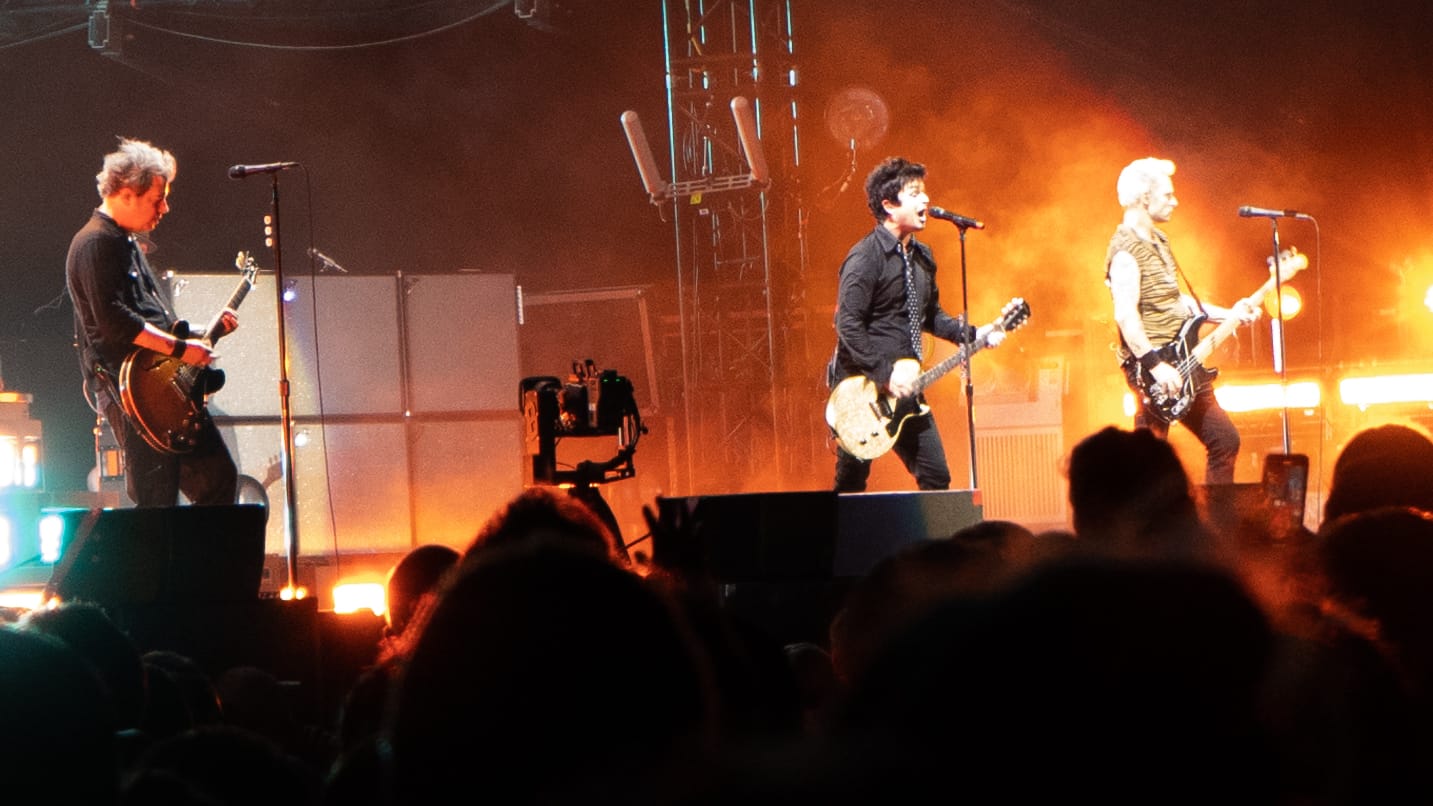 the band Green Day, three men on stage with guitars, during a show