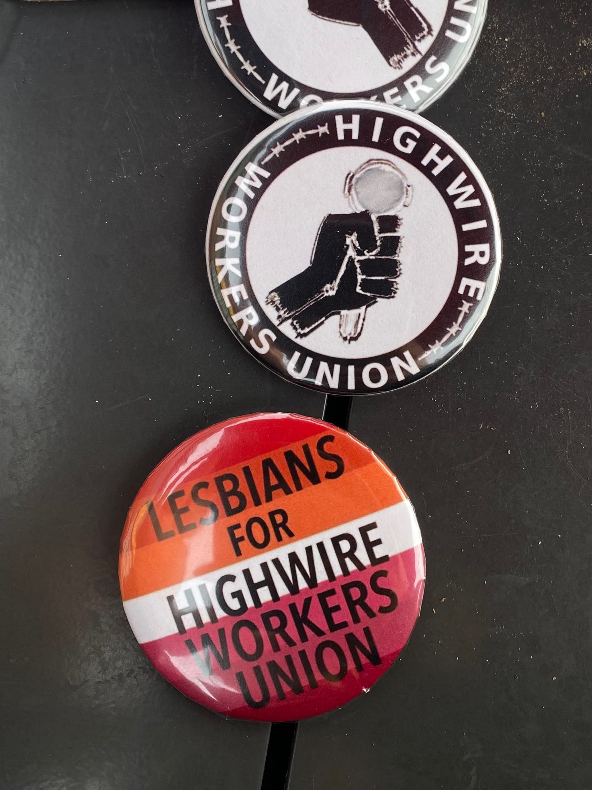 Pins that read Highwire Workers Union and Lesbians for Highwire Workers Union.
