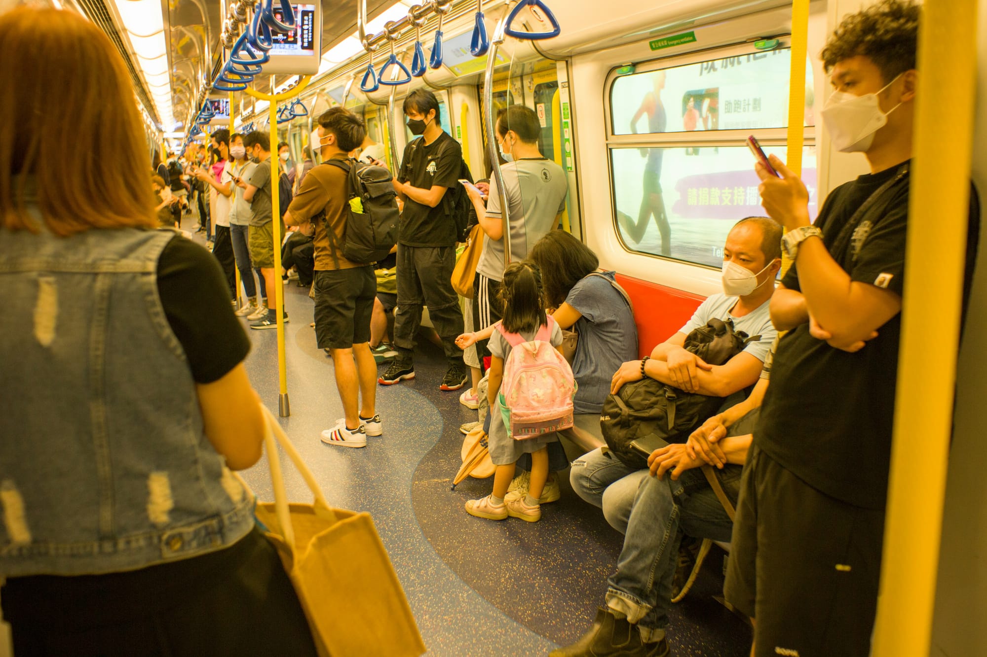 people on a train in Hong Kong, many with maks