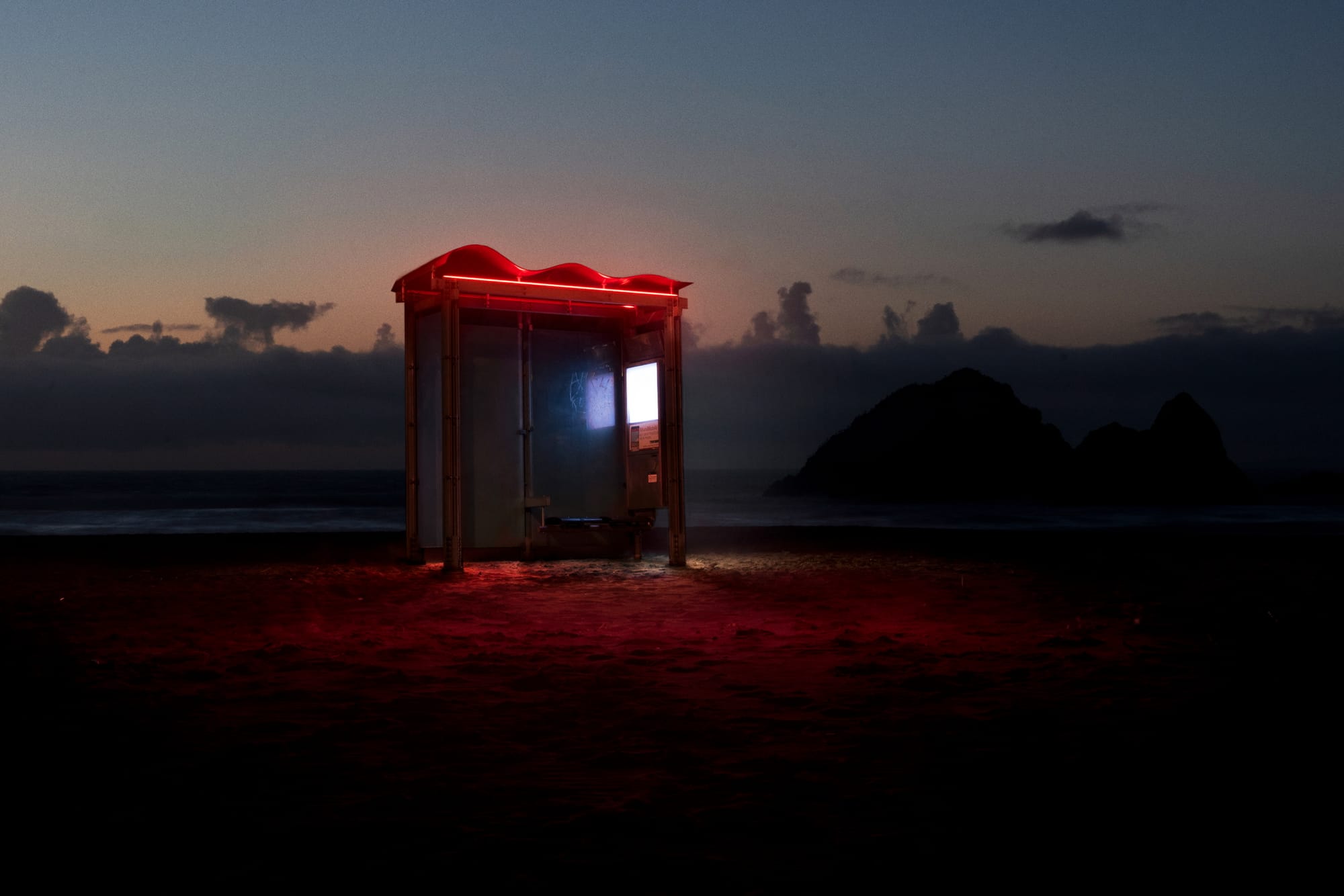 a lit-up bus station at the ocean