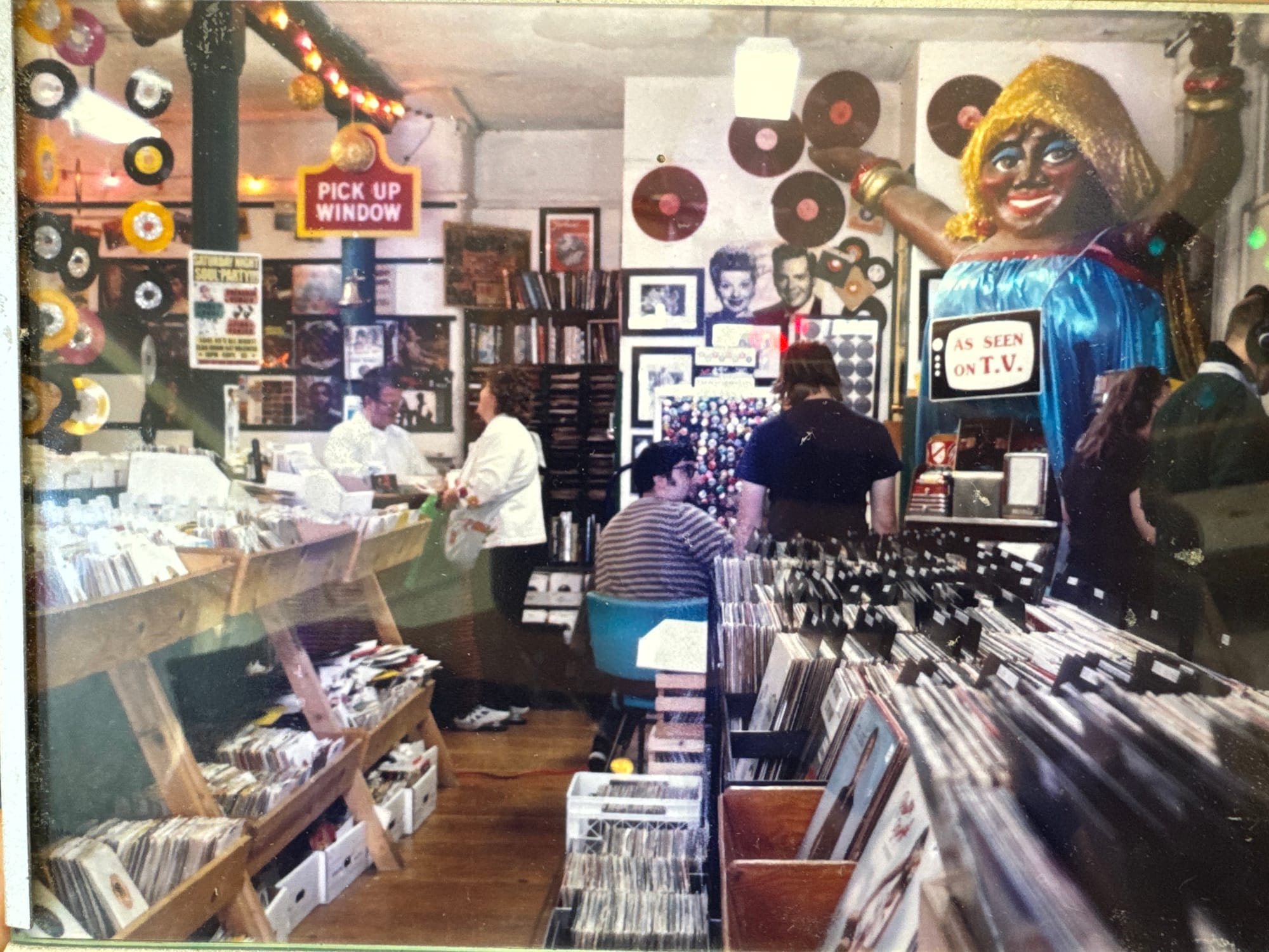 an old photo of the interior of a record shop with people in it