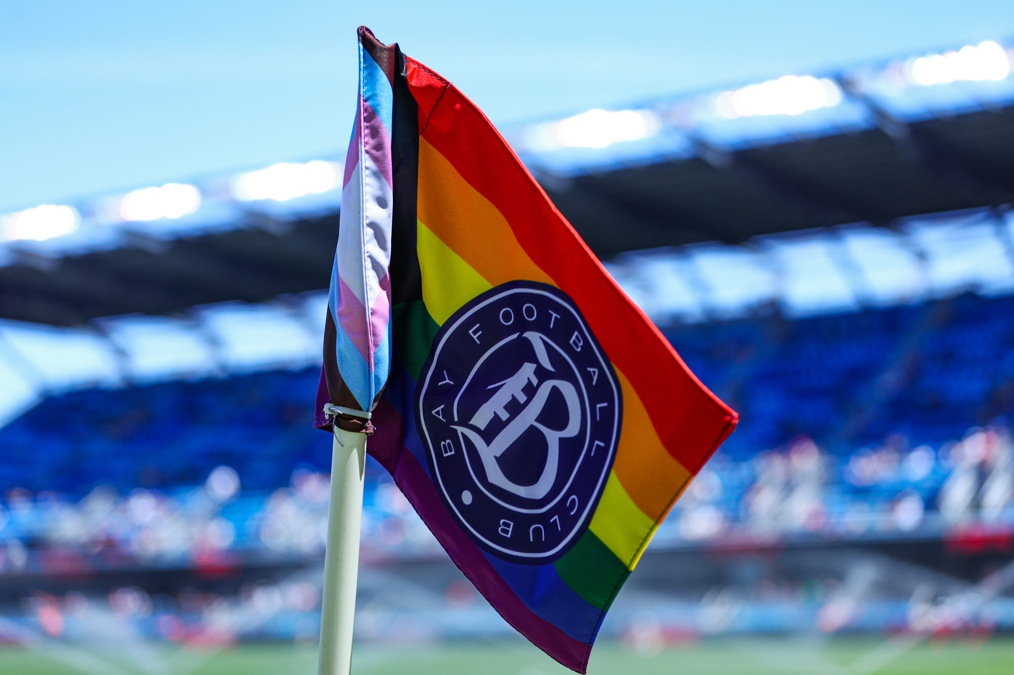 a rainbow Bay FC flag at a soccer game