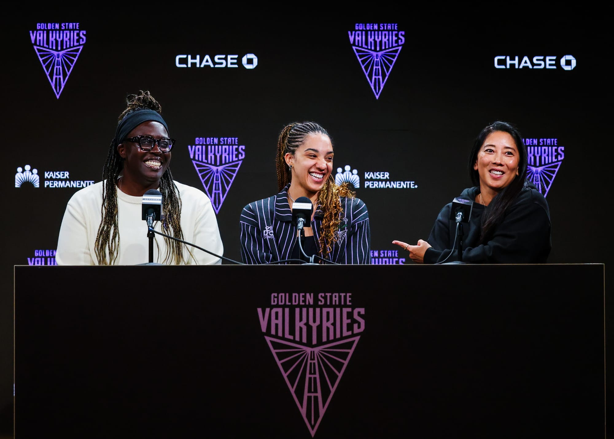 Three women sitting at a table with the "Golden State Valkyries" emblem in front