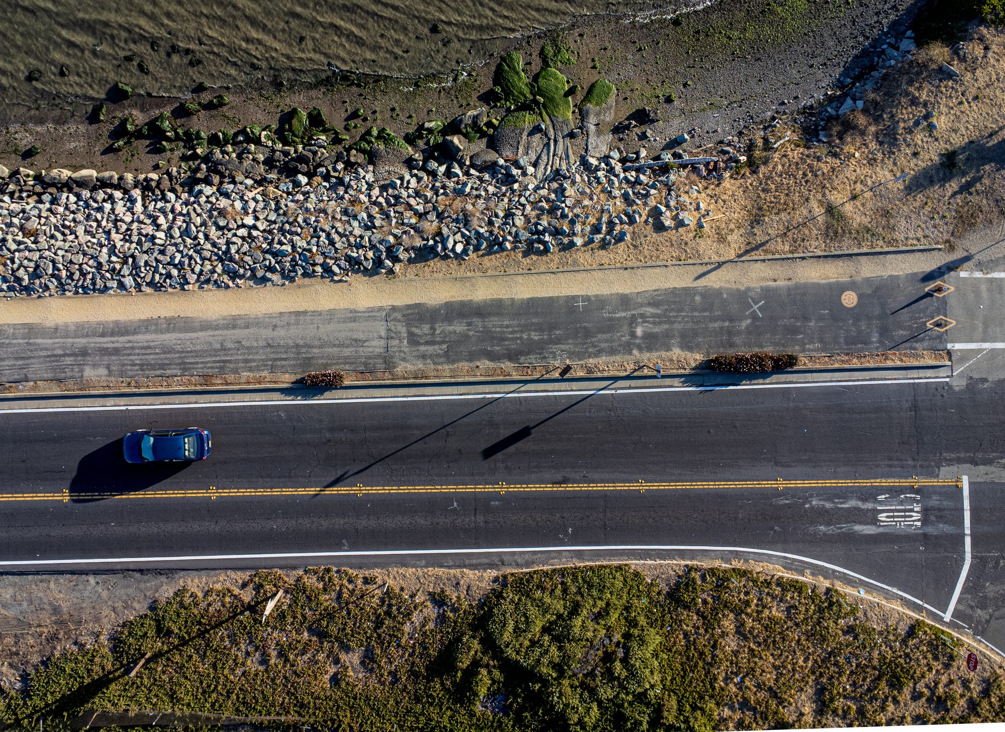 an aerial drone image of a freeway in Emeryville with a single car on it