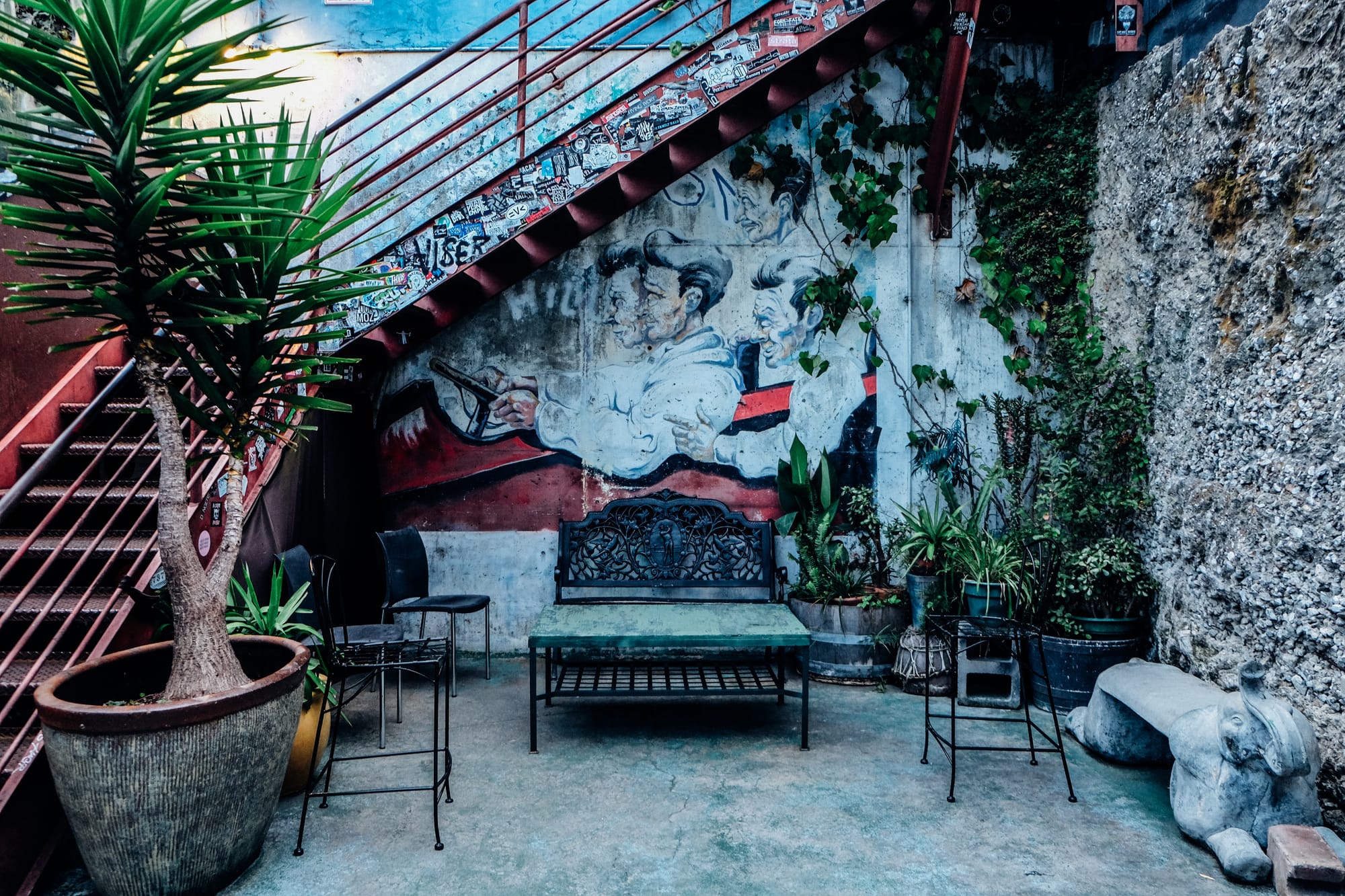 the back patio of a music venue with benches and stairs leading to the second floor