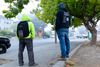 two men stand with their backs to the camera on a foggy street