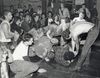 a black and white photo shows a chaotic punk show with people falling over