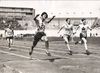 A black and white photograph of a Japanese woman crossing the finish line at the 1928 Olympics.