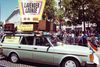 a car with a sign on it that reads 'lavender lounge, TV dance party for gay boys & girls' at a pride parade in SF)