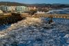 Waves crashing into a damaged concrete pier.