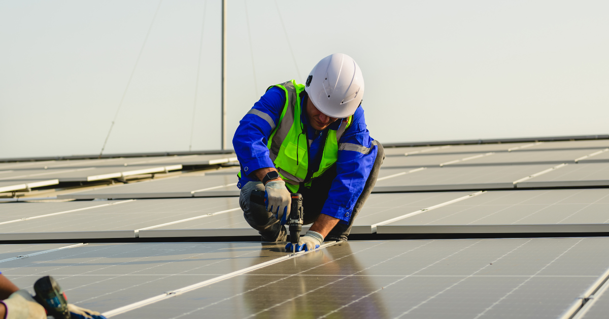 Integrador instala painéis solares com equipamento de segurança, destacando a sustentabilidade e a eficiência energética.