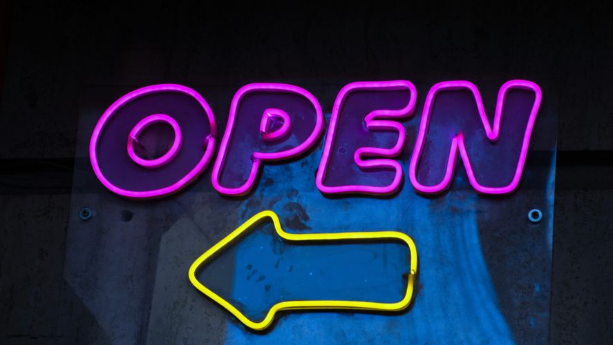 Neon "OPEN" sign with a yellow arrow pointing left