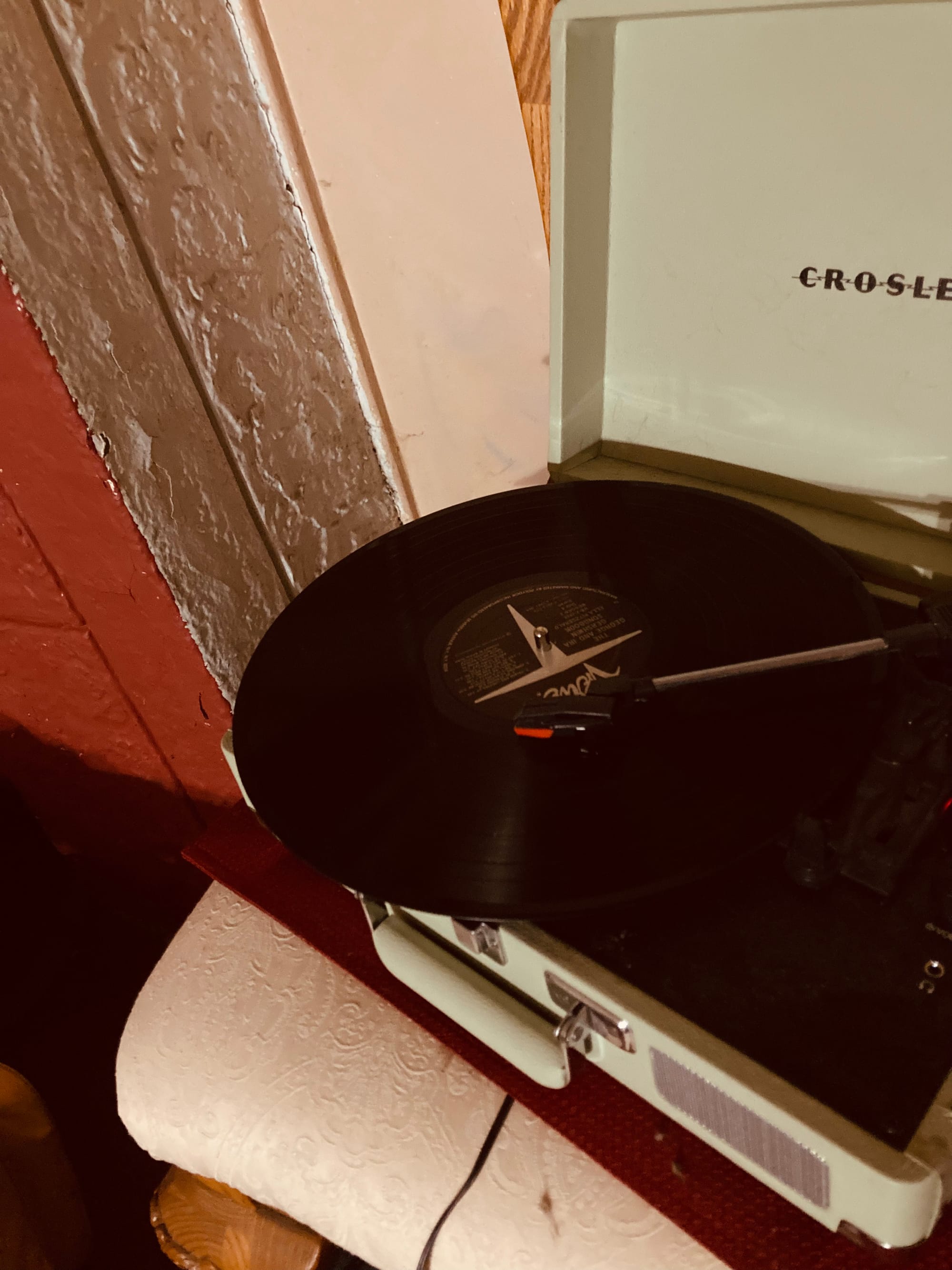 An album (Ella Fitzgerald sings Gershwin) in on a turntable with the needle on it. All of that is sitting on an elegant chair.