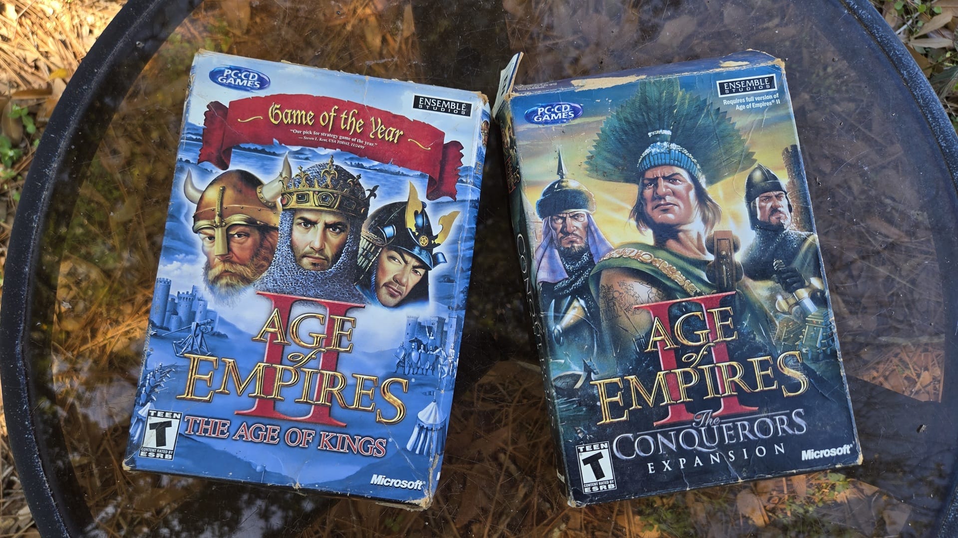 Two old PC game boxes for Age of Empires 2: The Age of Kings and The Conquerors Expansion.