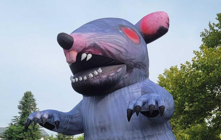 A giant inflatable rat with red eyes.