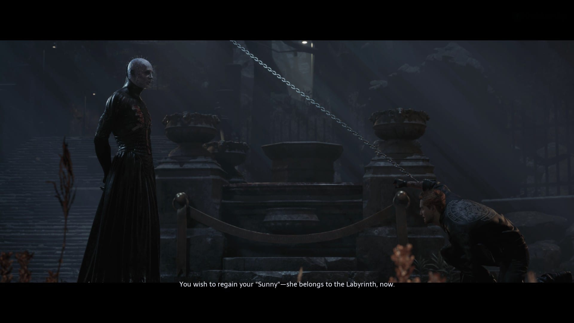 Pinhead talking with a man strung up on a chain, saying "You wish to regain your 'Sunny' -- she belongs to the Labyrinth, now."