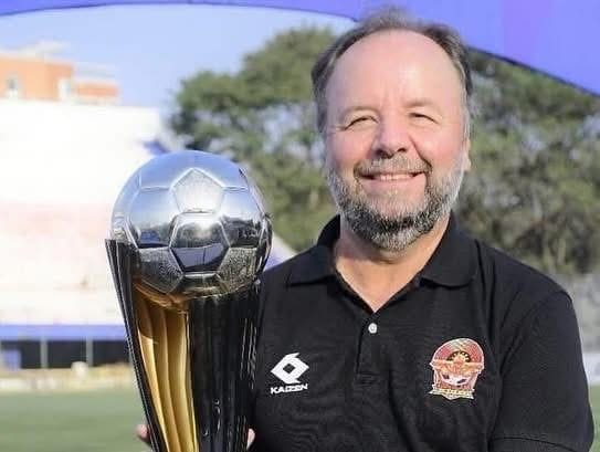 Luiz Greco holding the 2018 South American Cup trophy in an Athletico Paranaense polo shirt at the club's stadium.