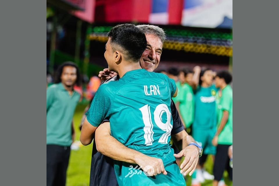 Luisma Hernández embracing a Maziya S&RC player wearing the number 19 jersey with the name ILAN on the back, after the team's Maldives league championship celebration.