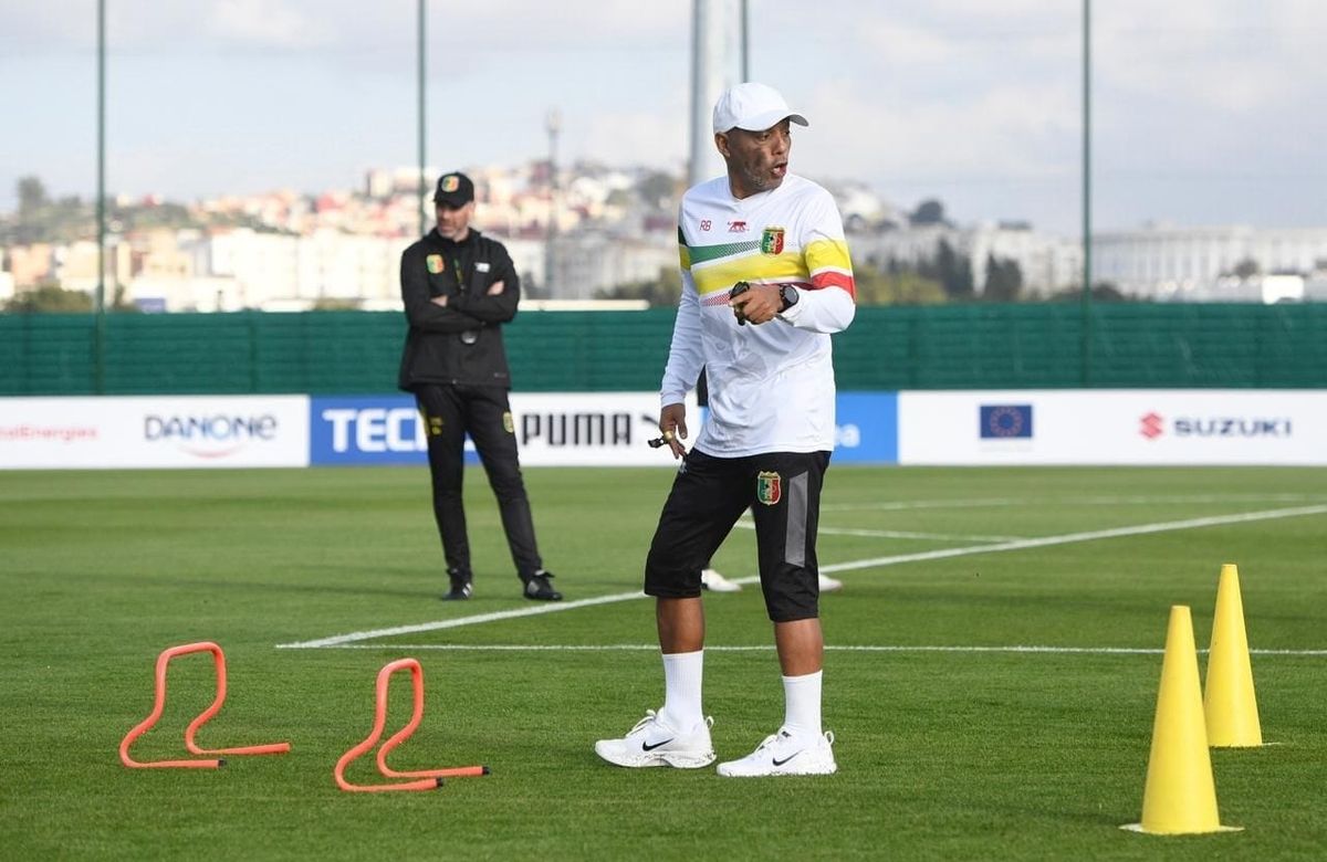 Riedoh Berdien, South African strength and conditioning coach, leading a Mali National Team training session with cones and hurdles on the pitch.