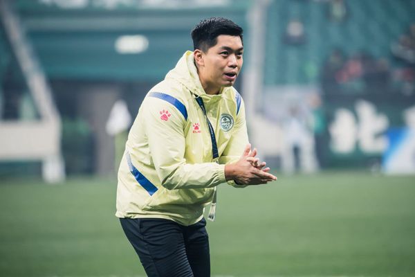 Norris Ng, Hong Kong football coach and performance analyst, in a yellow Tai Po FC training jacket directing players from the touchline during an AFC Champions League Two match.