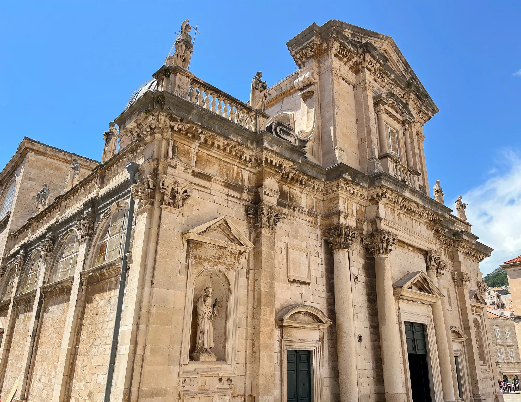 Tan stone baroque cathedral with statues of catholic saints
