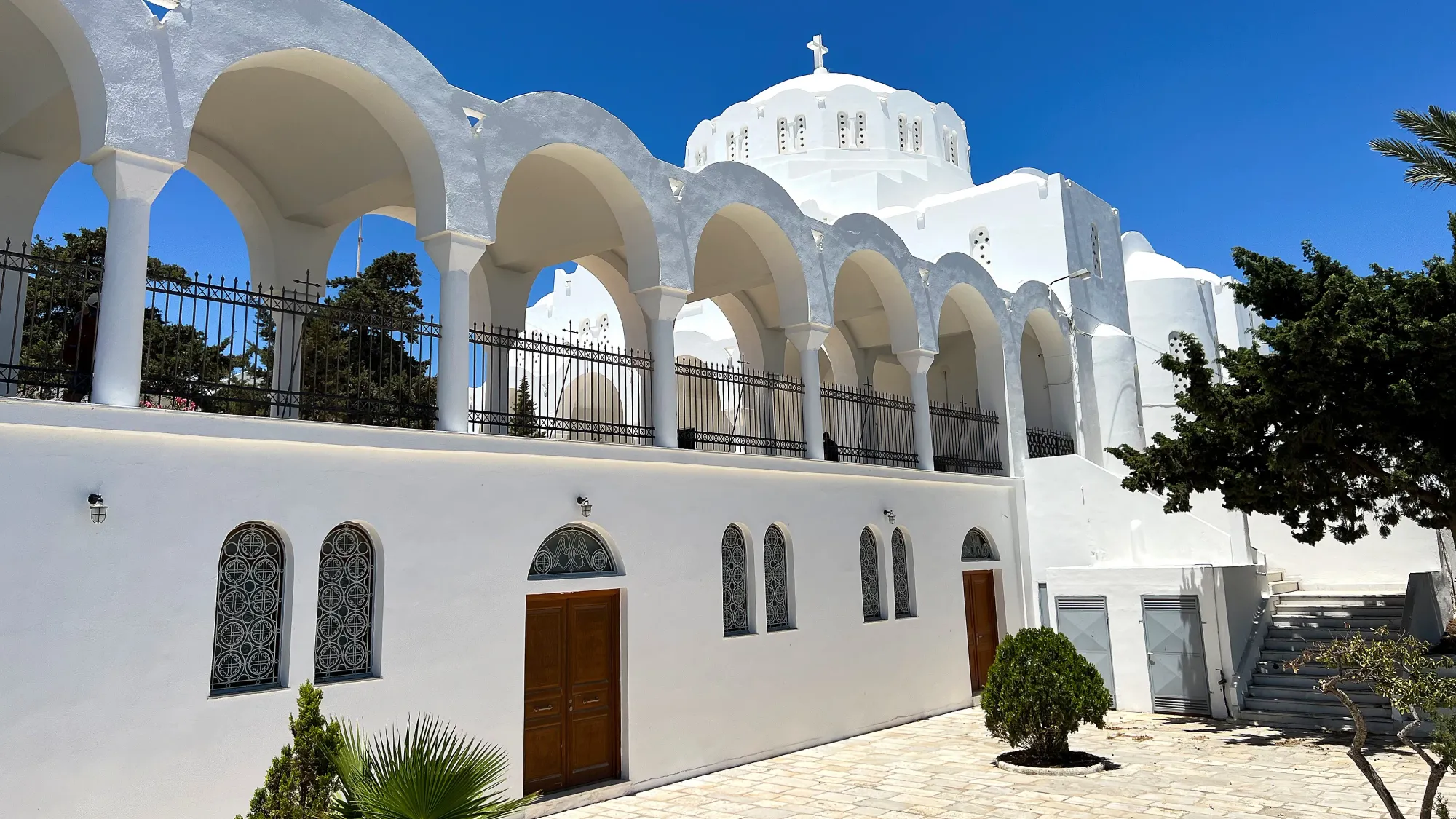 White washed building with a series of arches set before a domed roof