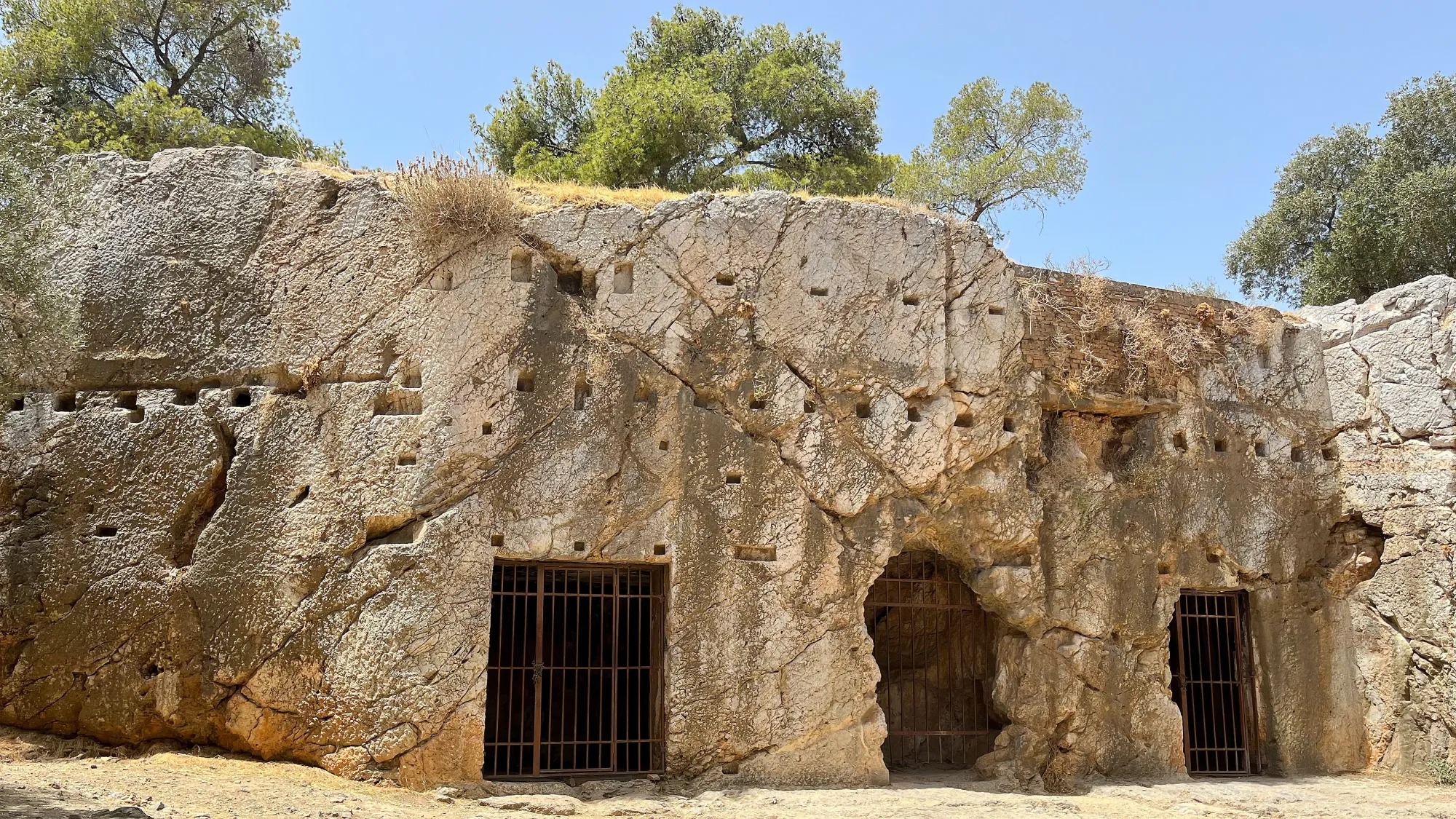 Stone wall with multiple indents with three metal grates in tact