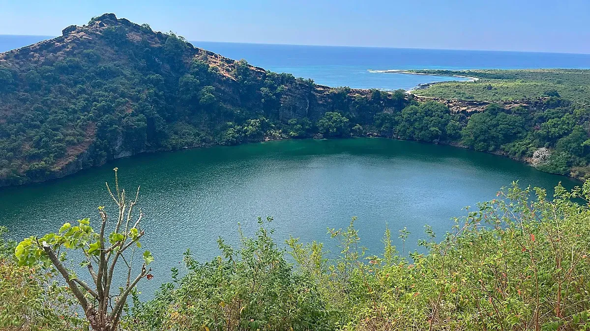 Round lake cut off from the ocean by a tall rock face