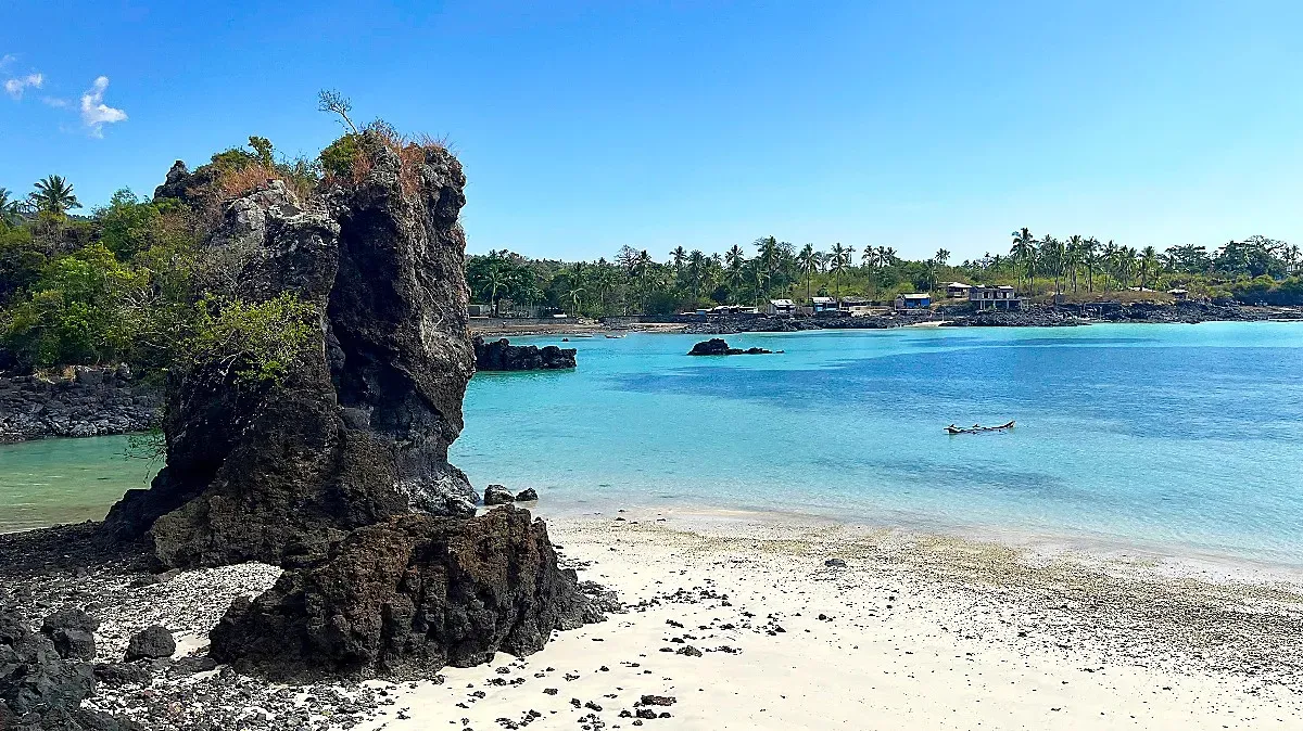 Black Rock figure jutting out of the sandy seaside