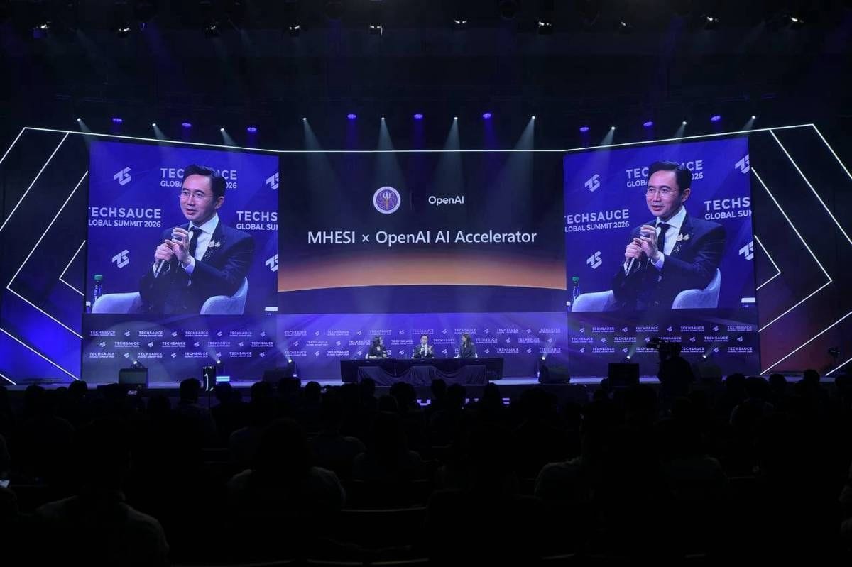 A Techsauce Global Summit 2026 stage screen displays MHESI x OpenAI AI Accelerator while speakers sit below.