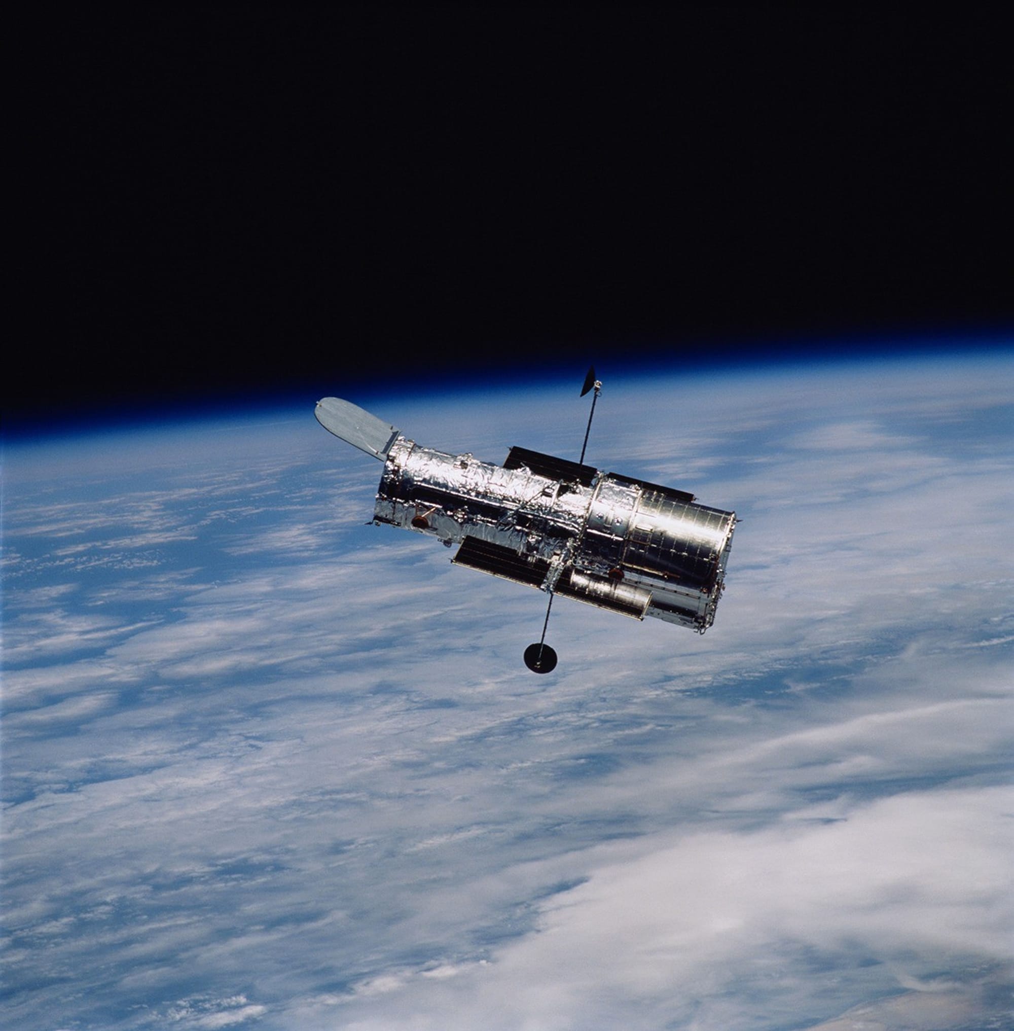 NASA image of the Hubble Space Telescope in orbit above Earth.