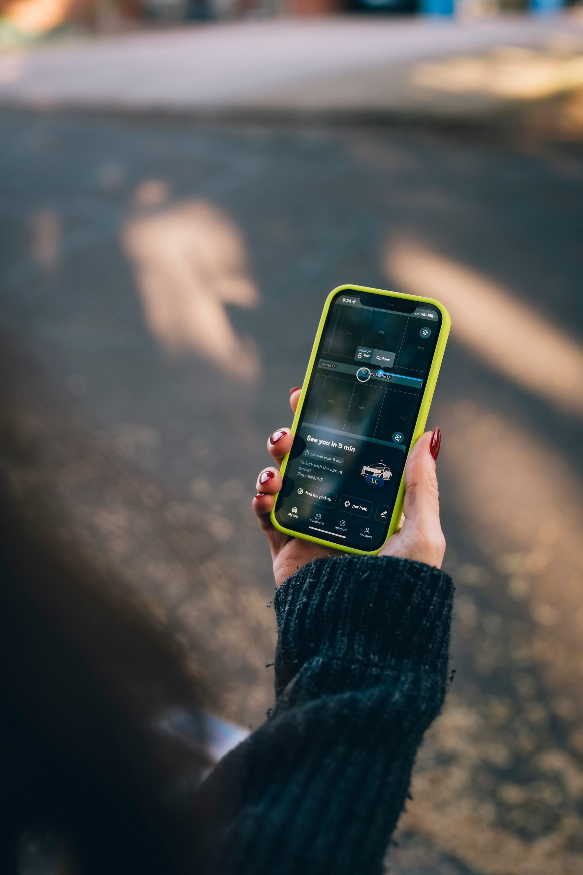 A passenger using the Waymo ride-hailing app on a smartphone.
