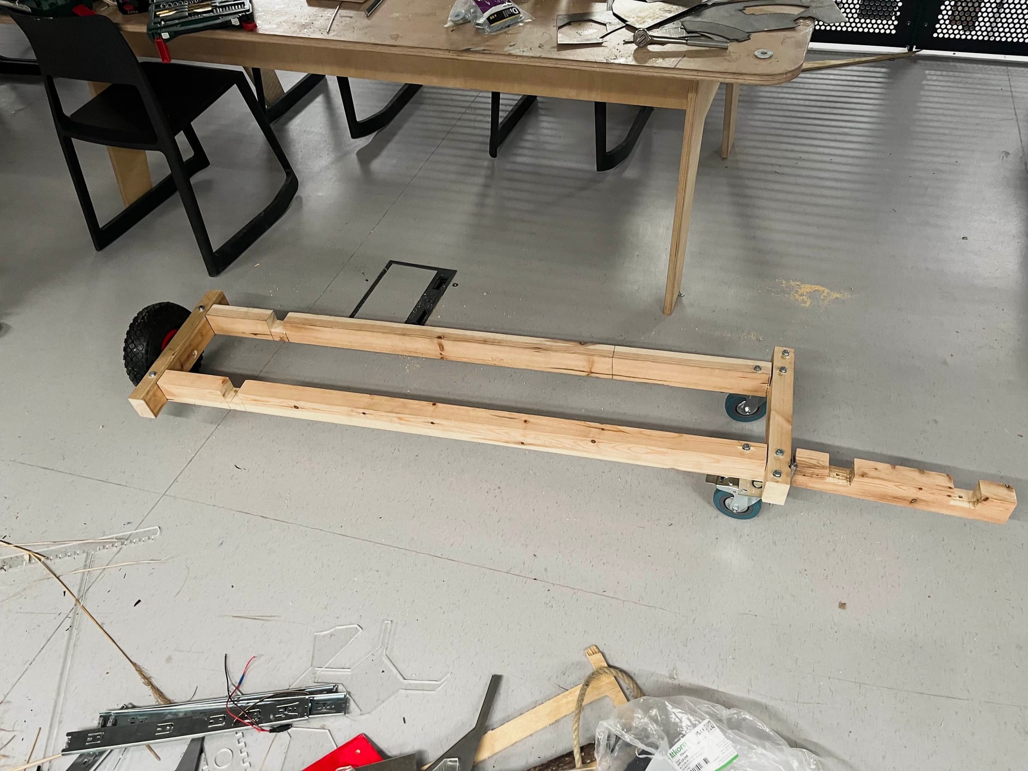 Photograph of wheeled door component of wooden base frame.