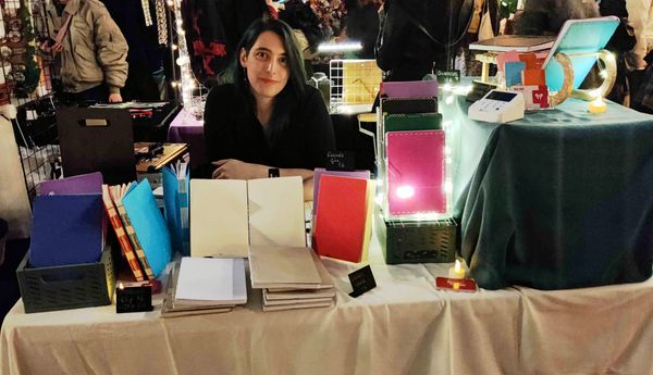Une photo de moi assise derrière un stand de vente de carnets faits à la main