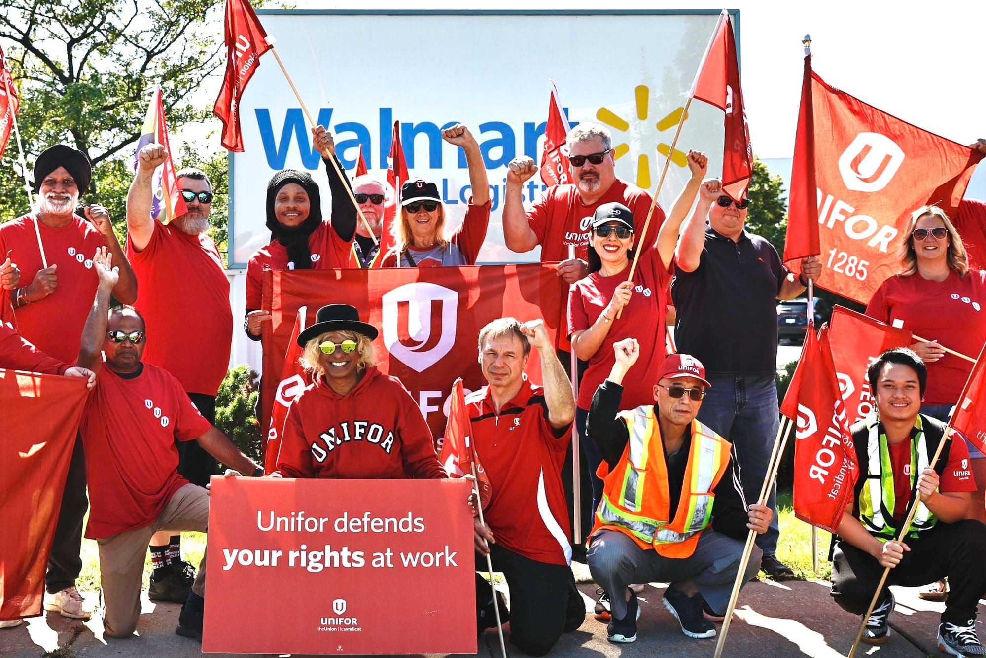 Unifor workers in front of a Walmart sign