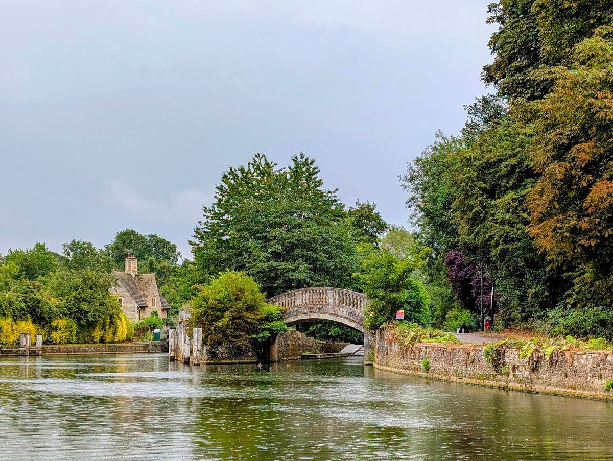 Image of a stone bridge over the river Thames in Oxford, UK with a stone house across the river.