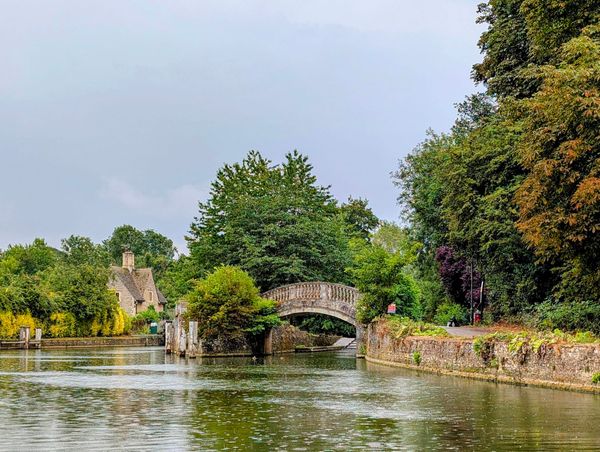 Image of a stone bridge over the river Thames in Oxford, UK with a stone house across the river.