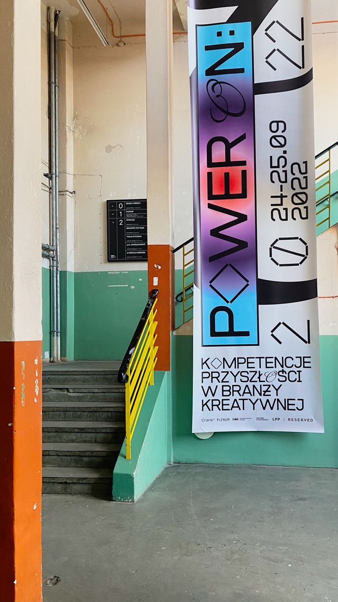 Banner konferencji Power On wiszący w korytarzu w Plenum.