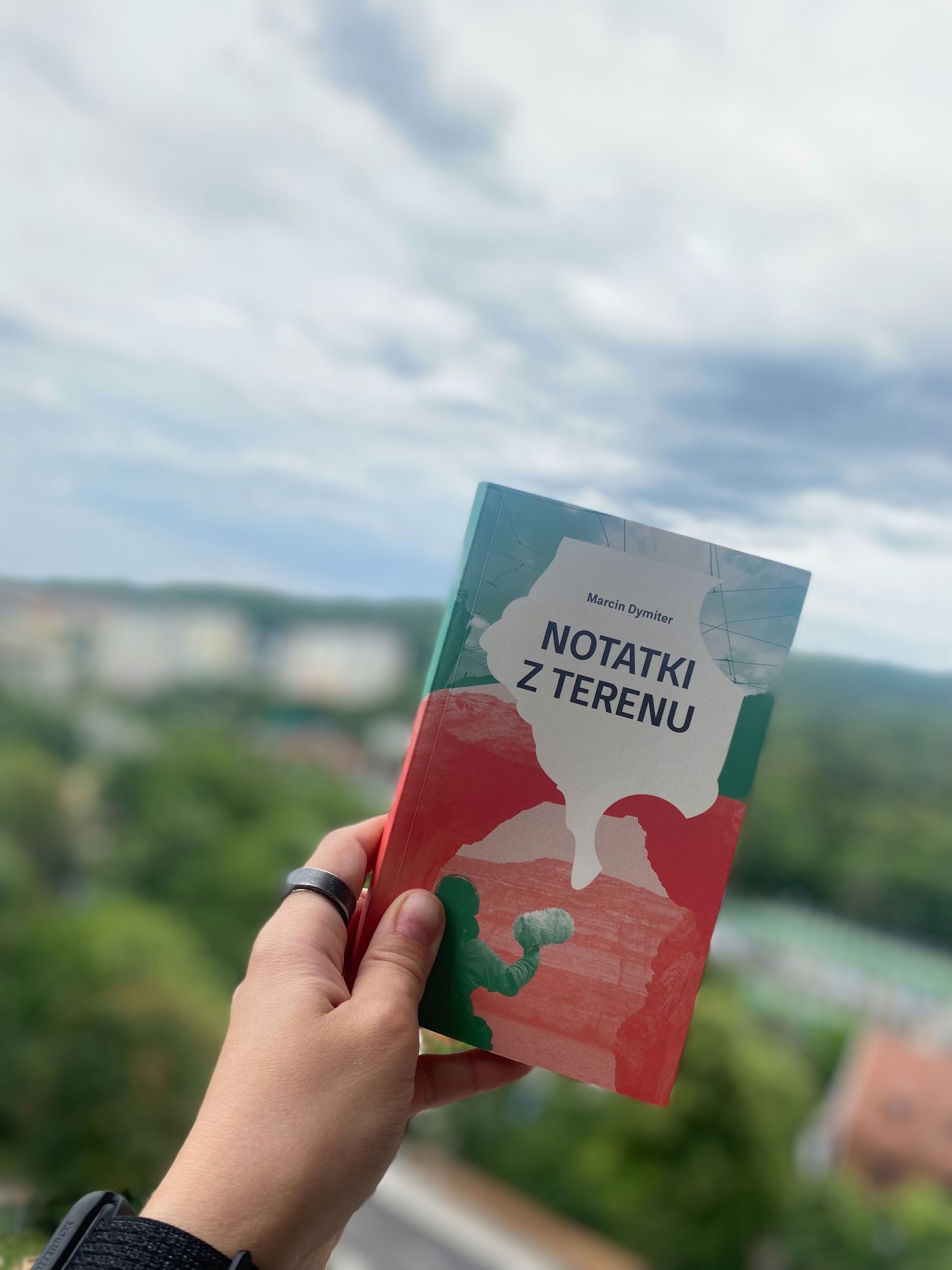 Ręka trzymająca książkę "notatki z terenu" 