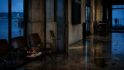 Sala d’attesa mediterranea al crepuscolo con un filo rosso sul pavimento, un melograno aperto e il riflesso alterato di una sedia, richiami ai miti di Arianna, Persefone e Narciso.